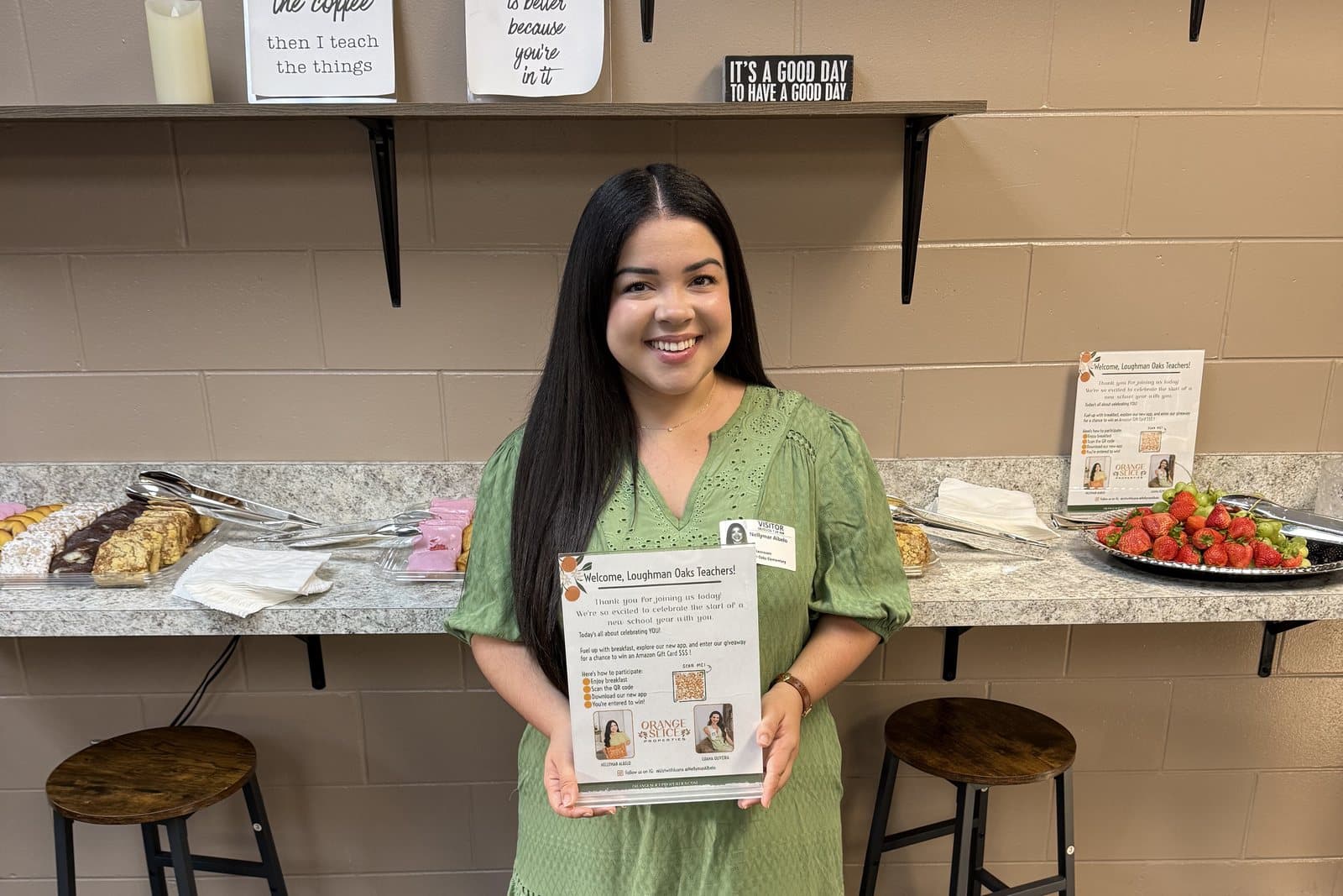 A welcome flyer for Loughman Oaks teachers held up in the teachers' lounge, next to a breakfast spread with fresh strawberries